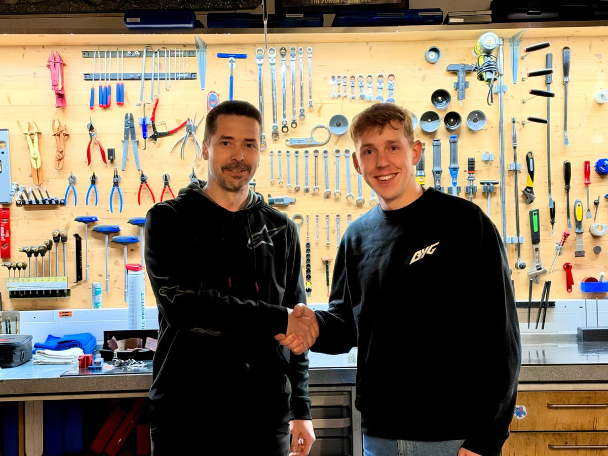 Klaus Aumüller und Manuel Gumpenberger beim Handschlag vor der Werkzeugwand der Werkstatt